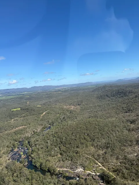 Aerial view of a river winding through dense Tablelands bushland.