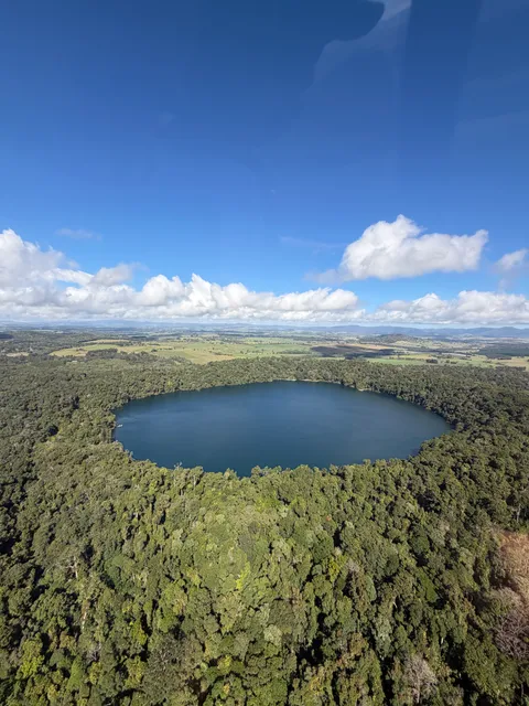 Aerial view of a volcanic crater lake ringed by rainforest, Lake Eacham.