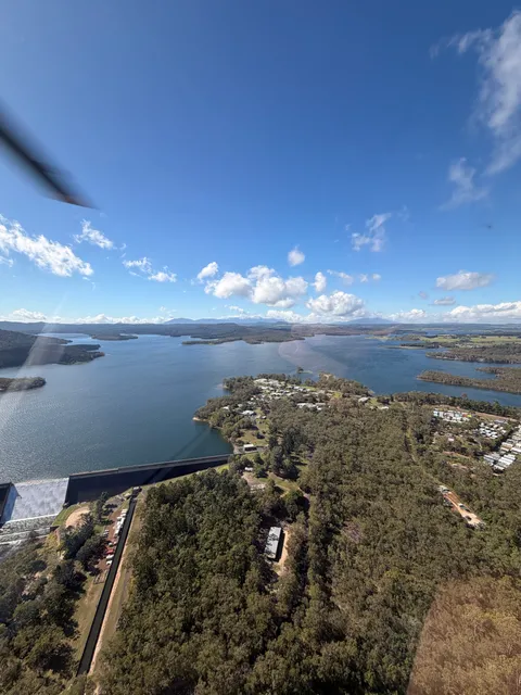 Aerial view of Tinaroo Dam wall with the lake and township beyond.
